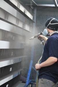 employee spraying frame of poly carbonate door